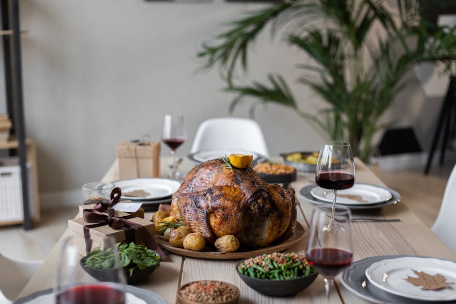 From above of palatable roasted turkey and glasses of wine on wooden table served for celebrating Thanksgiving